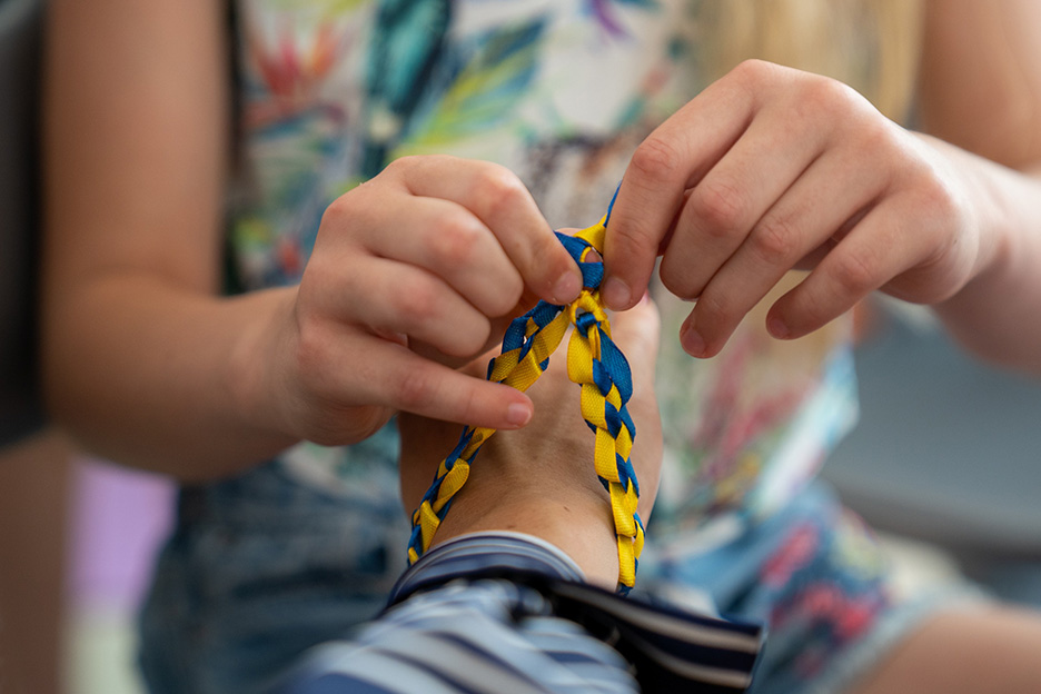 Armband mit ukrainischen Farben wird umgebunden.