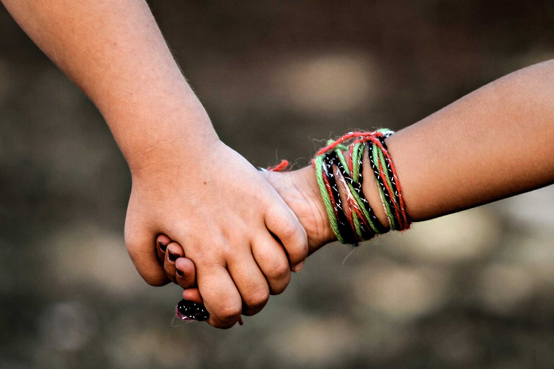 Zwei Kinder halten sich an der Hand