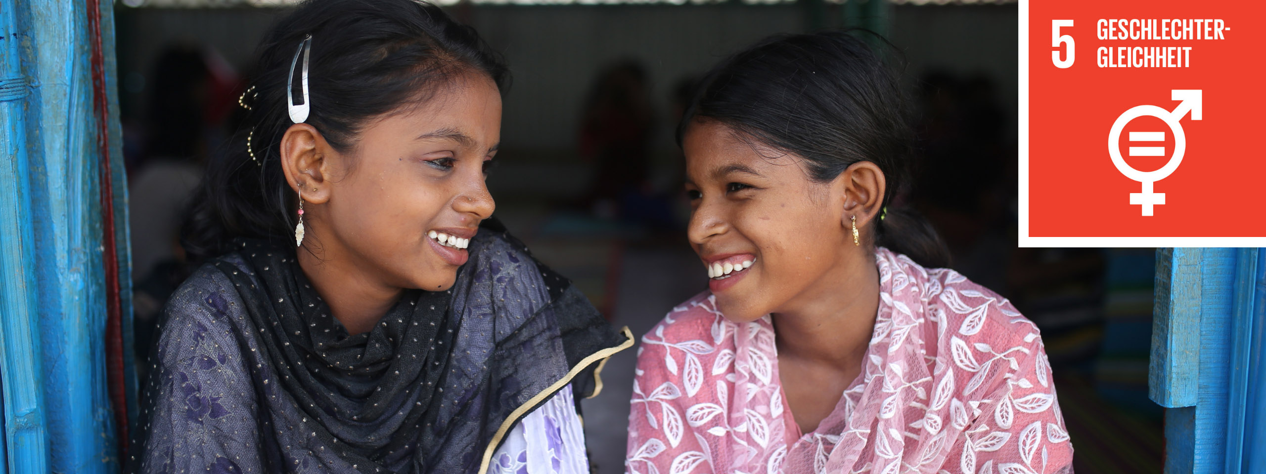 Zwei Freundinnen in Bangladesch lächeln sich an. 