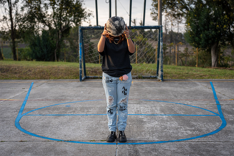 Maryan steht auf einem Sportplatz und hält einen Ball.