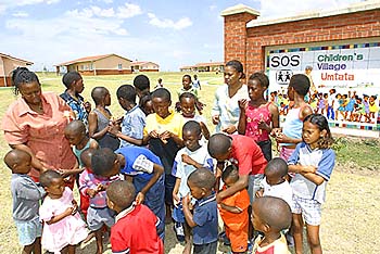 Kinder und Mütter am Eingang zum SOS-Kinderdorf Umtata