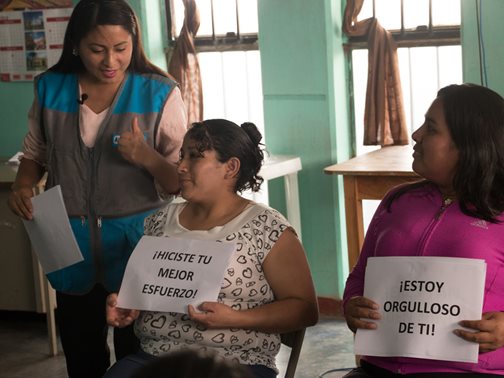 "Du hast dein Bestes gegeben" und "Ich bin stolz auf dich" heißt es auf den Schildern der Frauen. Die beiden sind Teilnehmerinnen eines Familien-Stärkungsprogrammes in Peru und lernen, ihre Kinder konstruktiv zu ermutigen. Foto: Alejandra Kaiser