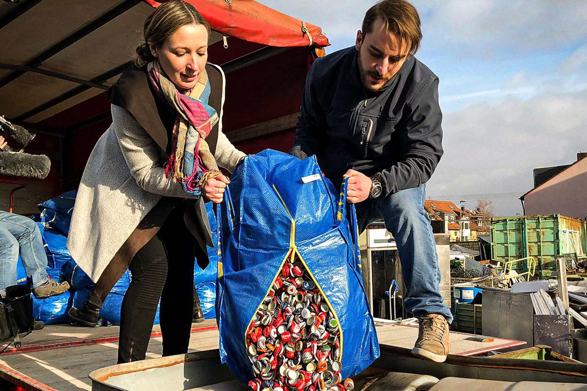 Alexandra Rybarski und ein Mann entleeren einen Sack gesammelter Kronkorken.