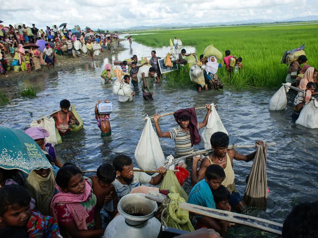 Rohingya-Flüchtlinge in Bangladesch waten durchs Wasser. Foto: Abir Abdullah / European Pressphoto Agency