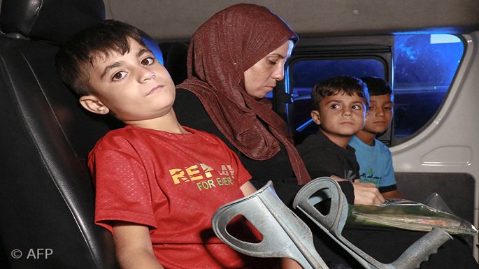 verletzte Kinder aus Gaza und ihre Mutter sitzen auf der Rückbank eines Autos. Foto: KHALIL MAZRAAWI / AFP