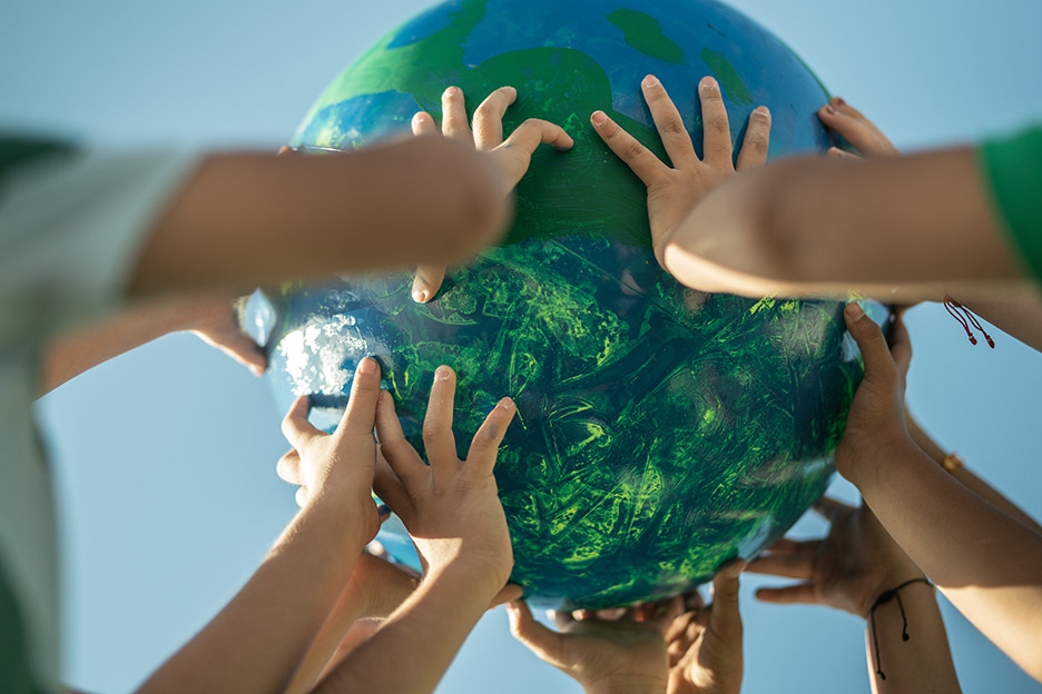 Kinderhände halten eine Weltkugel