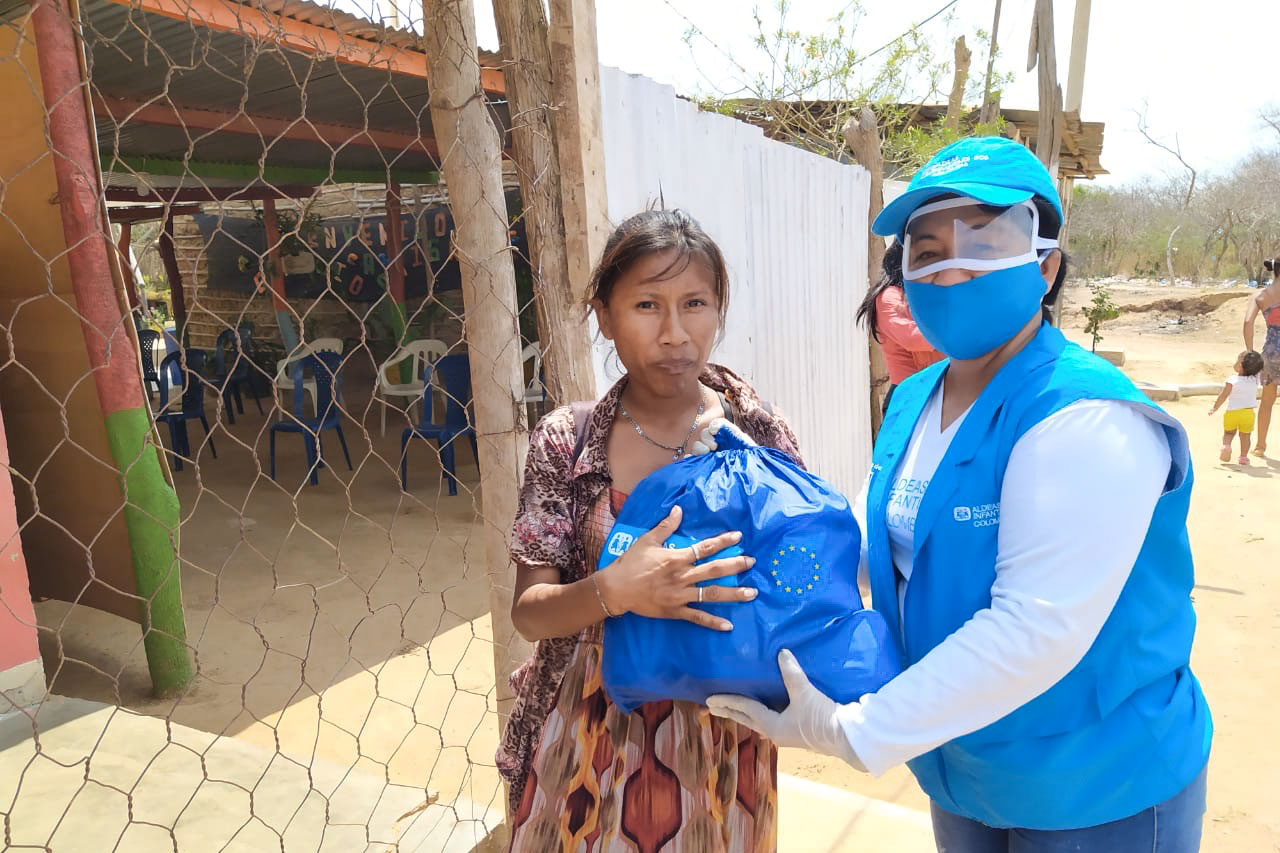 Helferin der SOS-Kinderdörfer verteilt Hilfsgüter