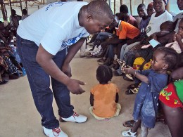 Im Flüchtlingslager in Liberia: SOS-Helfer mit einem Kind