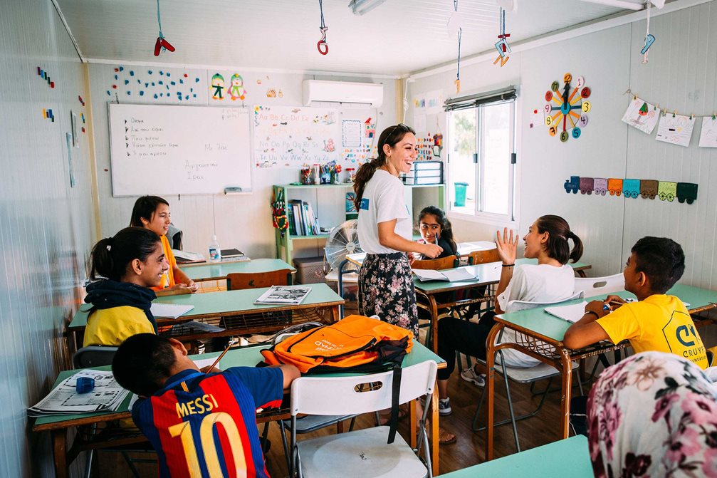 Eine junge SOS-Lehrerin steht im Klassenzimmer und unterrichtet Kinder im Lager Kara Tepe.